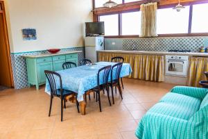 a kitchen with a table and chairs in a room at Villa Verde con vista sul mare in San Vito lo Capo +8 photos