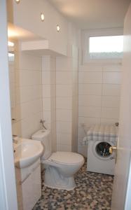 a white bathroom with a toilet and a sink at FeWo Ulamec Appartment VI in Velden am Wörthersee