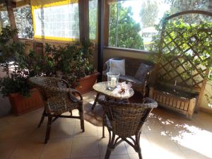 eine Veranda mit Stühlen, einem Tisch und Stühlen in der Unterkunft Hotel Ristorante La Bettola in Sasso Marconi