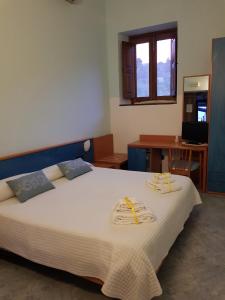 1 dormitorio con 1 cama blanca grande y toallas. en Il Delfino en Santa Marina Salina