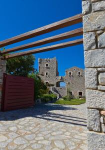 een toegang tot een kasteel met een rode poort bij Focalion Castle Luxury Suites in Pirgos Dhirou
