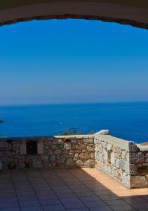 una pared de piedra con el océano en el fondo en Focalion Castle Luxury Suites, en Pyrgos Dirou