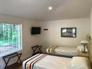 1 dormitorio con 2 camas y ventana en Carriage House On Kent en Niagara on the Lake
