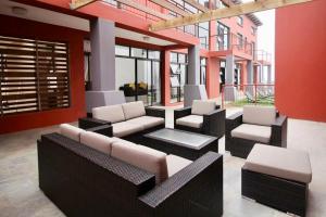 a patio with couches and chairs in a building at Scenery Guest House in Kokstad