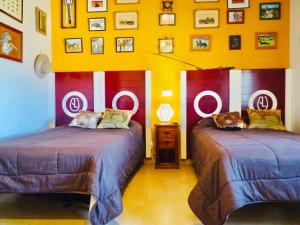 a room with two beds and a wall with signs at Casa Rural Yeguada Jimenez Latorre in Fernancaballero