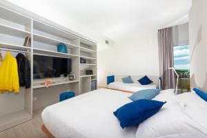 a bedroom with two beds with blue pillows at Amarina Hotel in Marina di Pietrasanta