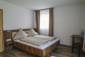 a bed with pillows on it in a room at LOOK Hotel & Rooms in Crailsheim