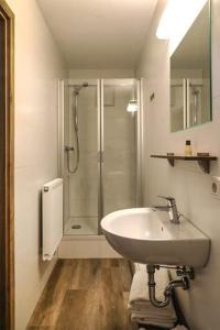 a bathroom with a sink and a shower at LOOK Hotel & Rooms in Crailsheim