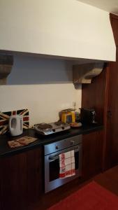 uma cozinha com um fogão e uma bancada em Casa do Castelo - Óbidos em Óbidos