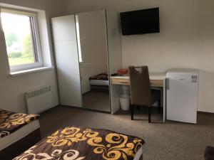 a small room with a desk and a refrigerator at Rychlebská bašta in Černá Voda