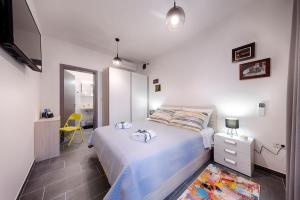 a bedroom with a bed and a yellow chair at En Suite Room Demaria in Komiža