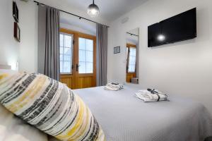 a bedroom with two beds and a flat screen tv at En Suite Room Demaria in Komiža
