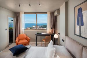 a bedroom with a bed and a desk with a window at Royal Suites-Sky in Split