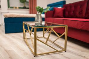 una mesa de centro de oro en una sala de estar con sofá en Golden Moonlight, en Zielona Góra