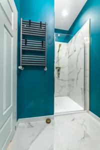 baño con ducha y pared azul en Golden Moonlight, en Zielona Góra
