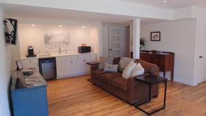 a living room with a couch and a kitchen at Carriage House On Kent in Niagara on the Lake