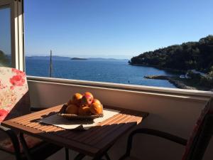 a bowl of fruit on a table in front of a window at Apartments Đurđa - amazing location in Sali