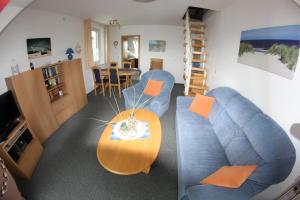 ein Wohnzimmer mit einem blauen Sofa und einem Tisch in der Unterkunft Skipper in Dorum Neufeld