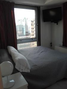 1 dormitorio con cama y ventana grande en Esmeralda Vista en Buenos Aires