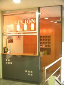 a reflection of a store window with the word open at Hotel Zaytun in Mequinenza