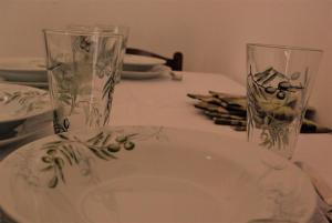 a table with two glasses and a plate on it at Romantic Apartment In Nature in Borovići