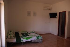 a small bedroom with a bed and a television at Romantic Apartment In Nature in Borovići