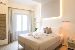 a bedroom with a bed with two towels on it at Light Blue Window Kamari in Kamari