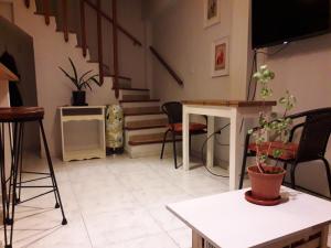 Sala de estar con escaleras y mesa con maceta en Duplex central en La Plata en La Plata