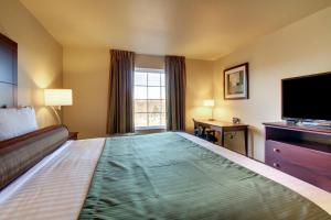 a hotel room with a large bed with a flat screen tv at Cobblestone Hotel & Suites - Charlestown in Charlestown