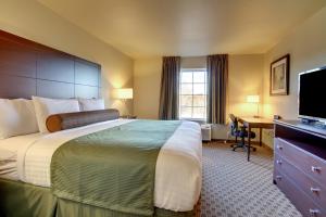 Habitación de hotel con cama grande y escritorio. en Cobblestone Hotel & Suites - Charlestown, en Charlestown