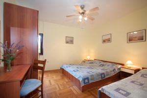1 Schlafzimmer mit 2 Betten und einem Deckenventilator in der Unterkunft Apartment Ante - sea view & serenity in Božava