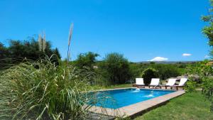 a swimming pool with two lounge chairs next to it at Rancho Escondido in Mina Clavero