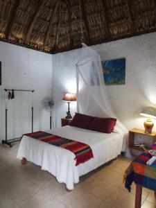 a bedroom with a bed with a mosquito net at Mayan Bungalow Near Chichén in Chichén-Itzá