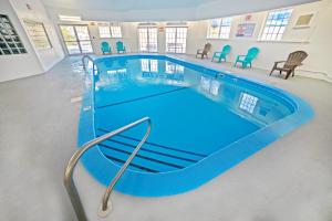 a large swimming pool with blue water in a building at The Stone Castle Hotel & Conference Center in Branson