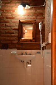 La salle de bains est pourvue d'un lavabo et d'un miroir. dans l'établissement Complejo de Cabañas Tierra Nuestra, à Mina Clavero