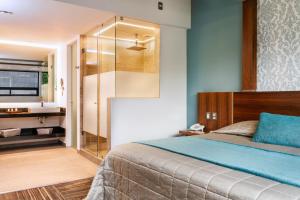 a bedroom with a bed and a shower and a sink at Kaia Suites in Ciudad L&oacute;pez Mateos