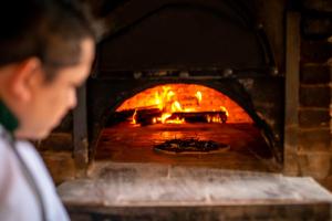 een man die voor een bakstenen oven staat bij Hotel Chichen Itza in Chichén-Itzá