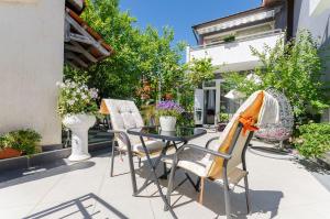 einen Tisch und Stühle auf einer Terrasse mit Blumen in der Unterkunft Apartment Ljubica in Vodice