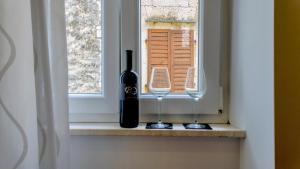 a bottle of wine and a wine glass on a window at The Little Gem in Komiža +120 photos