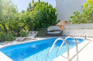 einen Pool mit zwei Gartenstühlen und einem Pool in der Unterkunft Apartment Ljubica in Vodice