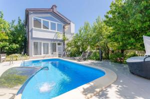 ein Swimmingpool vor einem Haus in der Unterkunft Apartment Ljubica in Vodice