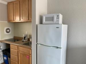 a microwave on top of a refrigerator in a kitchen at Dolphin Inn in Wildwood