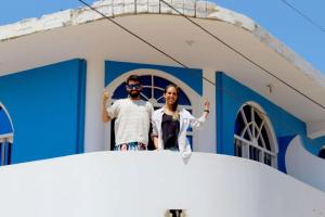 dos hombres parados en el frente de una iglesia en Hospedaje La Ola Azul, en Puerto Chicama