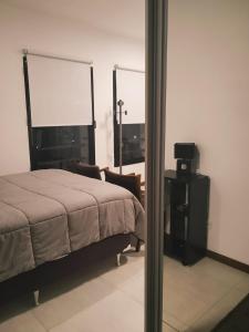 a bedroom with a bed and a chair and a window at Fado 103 in Colonia del Sacramento