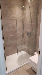 a bathroom with a shower with a glass door at Luxurious Luton town center flat with free parking in Luton