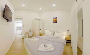 a white bedroom with a bed with towels on it at The Little Gem in Komiža