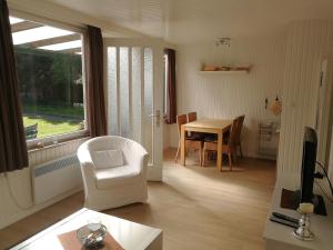 sala de estar con silla blanca y mesa en Campinghütte, en Fehmarn
