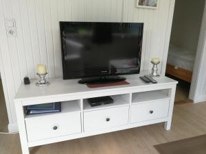 a white entertainment center with a television on it at Campinghütte in Fehmarn