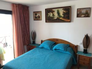 プラヤ・デ・ラス・アメリカスにあるHoliday Home Bungamarのベッドルーム1室(青いベッド1台、青い枕付)