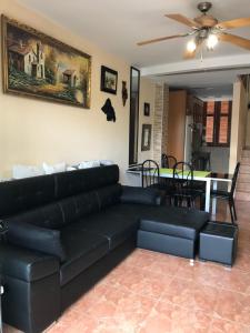 a living room with a black leather couch and a table at Holiday Home Bungamar in Playa de las Americas
